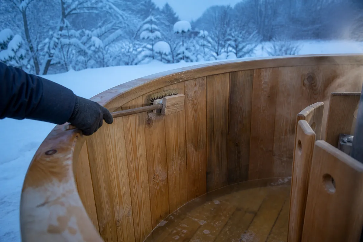 Brossage des douves en bois d’un bain nordique vidé au printemps